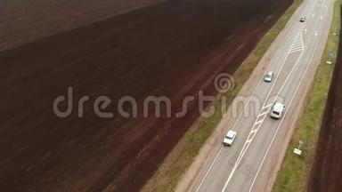 一条乡村沥青高速公路的鸟瞰图。 汽车沿着公路行驶. 汽车和卡车沿着乡村公路行驶